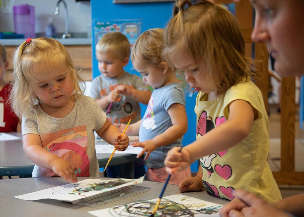A classroom of preschoolers doing a painting activity